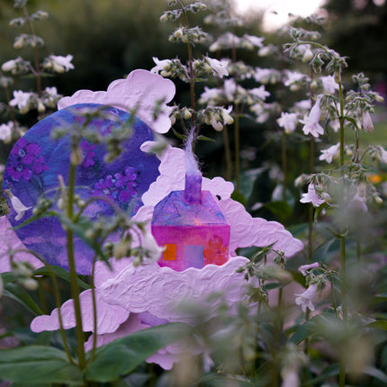 Colorful handmade sculpture among white foxglove flowers